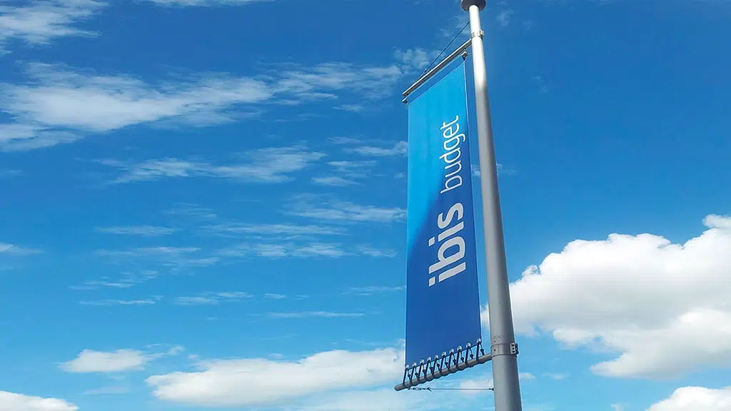 Baniervlag met rekkers fullcolour print op banner blockout gemonteerd in haakse baniermast
