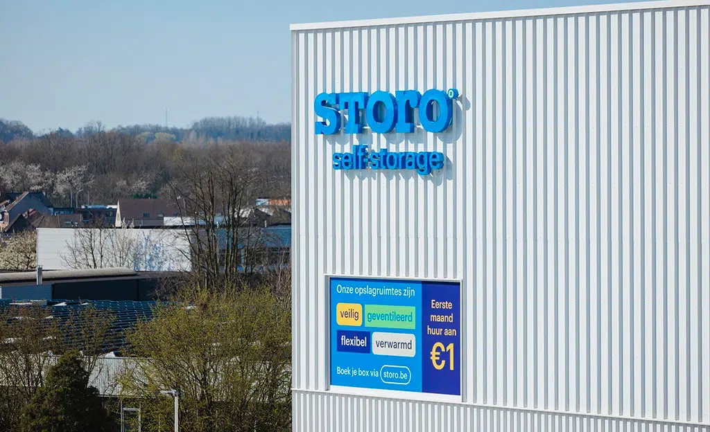 Professionele gevelreclame met verlichte 3D doosletters profiel5 gemonteerd op gevel en print op raamfolie AMS Antwerpen