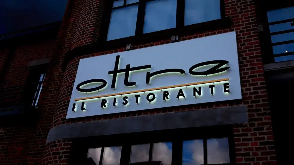 Outdoor nachtvisualisatie van een geveldecoratie met indirect verlichte 3D gevelletters voor een restaurant lichtreclame AMS Antwerpen