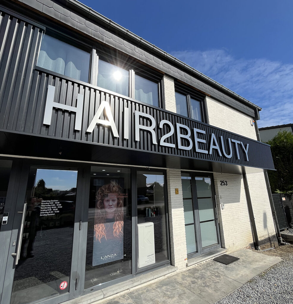 Gevelletters zilver geslepen RVS gemonteerd met afstandshouders op de gevel van een beautycenter AMS